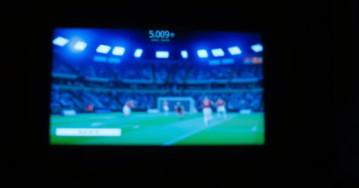 Dunkles Wohnzimmer nachts, beleuchtet vom Bildschirm eines Fernsehers mit Fußballübertragung, im Hintergrund leuchten weitere Geräte für parallele Streams.